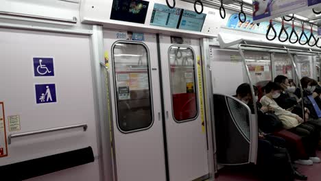 Innenraum-Eines-Fahrenden-Japanischen-U-Bahn-Zugwagens-Mit-Stadtpendlern