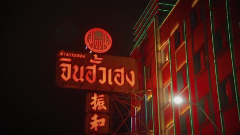 Red-neon-light-lights-up-building-on-a-dark-night-in-Chinatown,-Bangkok