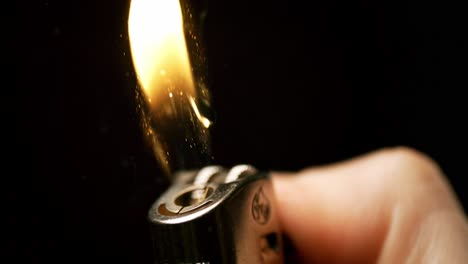 Igniting-grace:-Witness-the-enchanting-moment-as-sparks-bloom-into-flames-from-a-hand-holding-a-lighter,-captured-in-mesmerizing-slow-motion