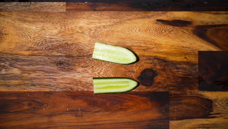 Top-view-of-a-male-hand-slicing-half-a-cucumber-in-half-perpendicular