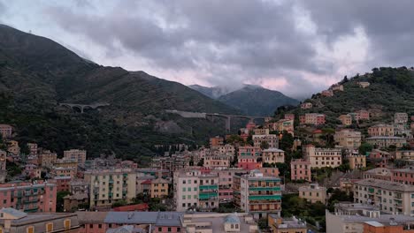 Evening-view-of-Genoa-Nervi,-Italy-with-colorful-buildings-nestled-in-lush-green-hills