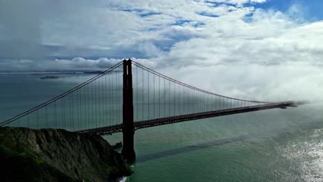 Clouds-flowing-on-Golden-Gate-bridge-in-San-Francisco,-California,-USA,-aerial-view