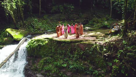 Traditional-ceremony-by-indigenous-people-near-a-waterfall-in-Pucallpa,-Peru,-surrounded-by-lush-greenery