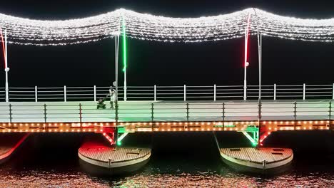 Tourists-enjoy-sparkling-lights-reflect-on-Caribbean-waters-above-bridge-floating-on-pontoons-in-Curacao