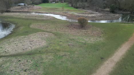 Ein-Gewundener-Fluss-Im-Southern-Park,-Norwich,-Mit-üppigem-Grün,-Luftaufnahme