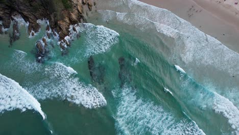 Bird's-Eye-View-Of-Ocean-Waves-Splashing-At-Broken-Head-Beach-In-NSW,-Australia---Drone-Shot