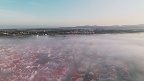 Vista-Aérea-Panorámica-Del-Tejado-Rojo-Que-Envuelve-Nubes-De-Niebla-En-Portugal