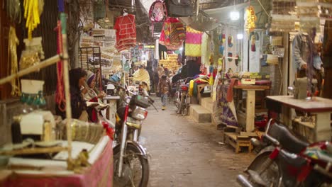 Gente-Caminando-Por-Las-Calles-Durante-Un-Mercado-En-Pakistán-Mientras-Se-Acerca-Un-Scooter