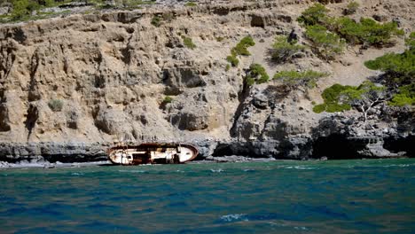 Refugee-Shipwreck-on-the-beach-of-Asterousia-in-Crete,-rocks-of-geological-interest-at-background
