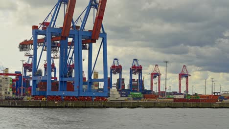 Profile-view-of-a-buy-commercial-port-of-Hamburg-with-cranes-at-working-during-a-cloudy-day-in-Germany