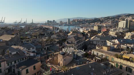 Genoa's-historic-center-with-old-buildings-and-distant-port,-clear-day,-aerial-view