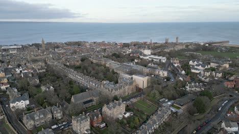 Aerial-Upwards-Of-Saint-Andrews,-Town-And-Saint-Andrews-Cathedral-In-Background