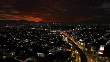 Drone-following-cars-on-the-Circuito-Interior-Ave,-dramatic-dusk-in-Mexico-City