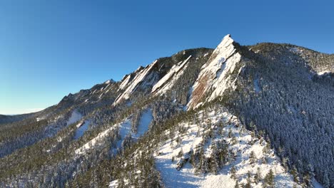Snowy-mountain-top-of-the-Boulder-Flatirons-near-Denver-Colorado-aerial-drone-Video-of-winter-landscape