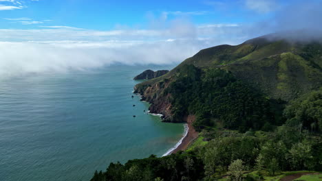 Aerial-view-flying-along-the-Marin-Headlands,-sunny-day-with-fog-in-Calfornia,-USA