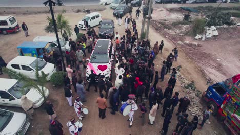 Aerial-view-of-wedding-car-arriving-while-money-is-thrown-towards-the-wedding-couple
