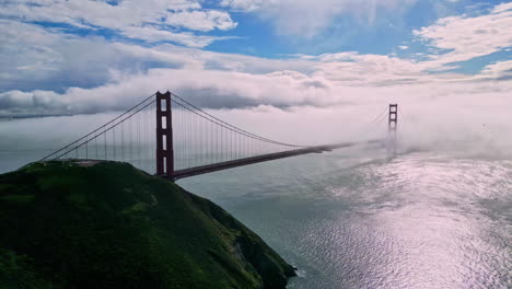 Aerial-view-descending-in-front-of-the-Golden-gate-bridge,-in-foggy-San-Francisco