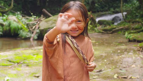 Smiling-indigenous-girl-waving-in-Pucallpa,-Peru-with-natural-backdrop