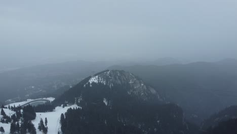 Landschaft-Aus-Bergen-Voller-Kiefern-Und-Schnee-Und-Einem-Nebligen-Himmel-Während-Eines-Winterschneefalls