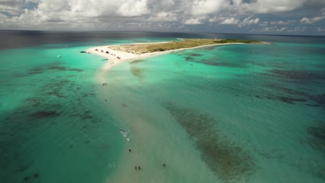 Los-roques-archipelago-in-venezuela-with-clear-turquoise-waters,-white-sandy-beach,-and-visitors-enjoying-the-tropical-paradise,-aerial-view