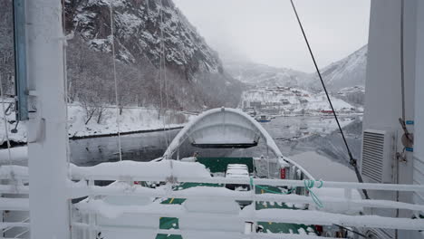 POV-footage-of-a-ferry-boat-ride-through-Geirangerfjord,-Norway,-highlighting-the-fjord's-tranquil-beauty-and-the-surrounding-snowy-mountains-in-winter