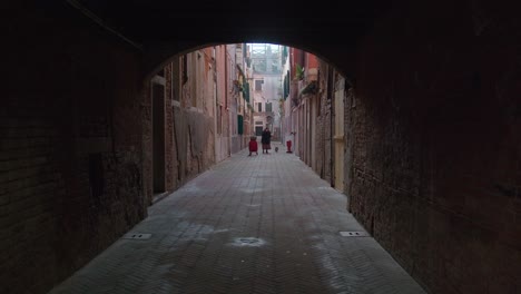 Archway-View-of-Venetian-Alleyway-with-residents,-Italy