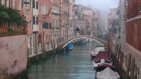Person-Crosses-Foggy-Canal-Bridge-in-Venice