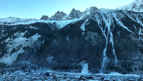 Inclinación-Aérea-Hacia-Abajo-Desde-Las-Espectaculares-Montañas-De-Los-Alpes-Para-Revelar-La-Estación-De-Esquí-Y-La-Ciudad-De-Chamonix,-Francia