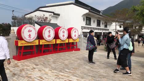 Tourists-take-pictures-next-to-a-display-in-Ngong-Ping-Village,-Hong-Kong