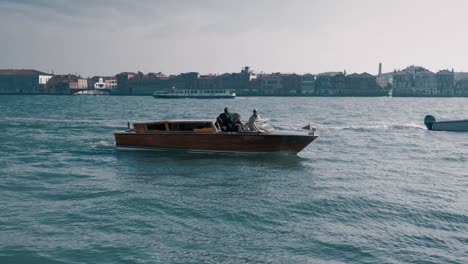 Wide-shot-of-a-mixed-raced-couple-having-a-privat-boat-trip-in-Venice-italy-enjoying-the-view-on-the-scenic-city-on-a-bright-sunny-day
