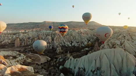 Hot-Air-Balloons-Flying-Over-Fairy-Chimneys-At-Sunrise-In-Cappadocia,-Turkey