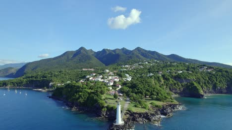 Drone-flying-towards-lighthouse-at-Vieux-Fort-with-beautiful-landscape-in-background,-Guadeloupe