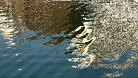 Rippling-water-reflecting-light-with-a-hint-of-surrounding-architecture