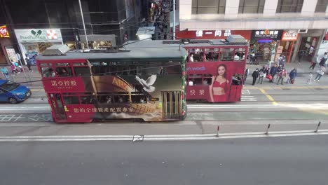Top-view-of-busy-Johnston-Road-with-trams-and-cars-passing-by-during-daytime-in-Wan-Chai,-Hong-Kong