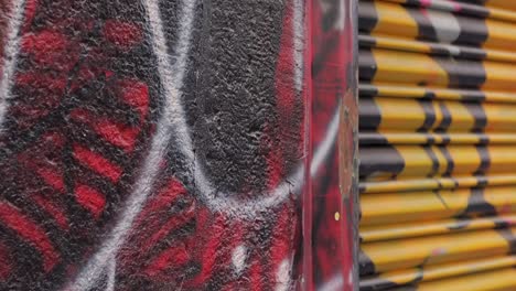 Rote-Und-Gelbe-Urbane-Graffiti,-Die-Auf-Und-über-Garagentoren-Gemalt-Sind,-Aus-Nächster-Nähe