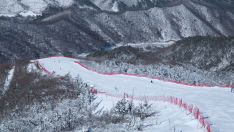 People-Skiing-Downhill-of-Balwangsan-Mountain-Slopes-in-Yong-Pyong-Ski-Resort-Pyeongchang-gun---Slow-Motion-Aerial-view