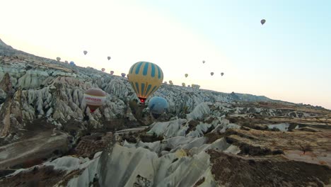 Hot-Air-Balloons-Taking-Flight-In-Cappadocia,-Turkey---Aerial-FPV