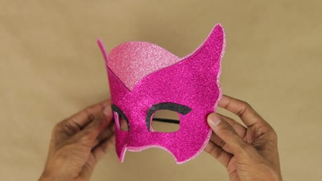 Hands-making-Owlette-mask-with-pink-diamond-foam-for-carnival
