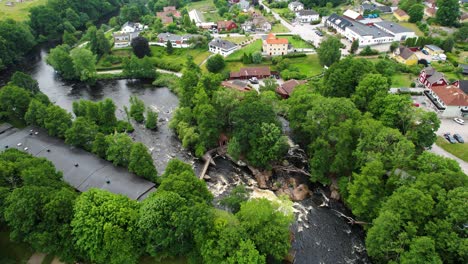 Laxens-hus-by-morruman-river-in-morrum,-sweden-with-lush-greenery-and-cascading-waters,-aerial-view
