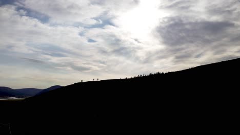 Silhouette-of-people-climbing-a-mountain