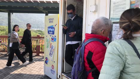 Bus-conductor-counts-people-leaving-the-bus-from-Ngong-Ping-Village-as-they-depart-in-Tai-O,-Hong-Kong