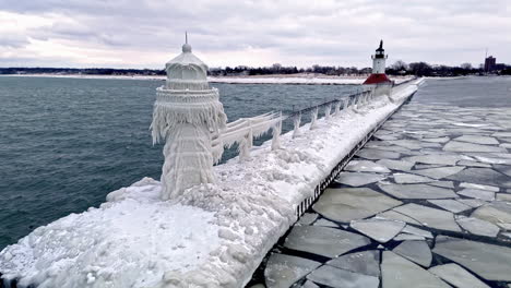Static-drone-shot-in-front-of-the-icy-Saint-Joseph-Lighthouse,-winter-at-lake-Michigan