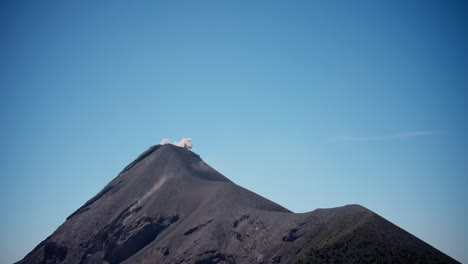 Daytime-eruption-at-Fuego-Volcano,-serene-scene-with-small-ash-cloud
