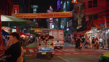 Traffic-driving-down-decorated-red-neon-highway-in-Chinatown,-Bangkok