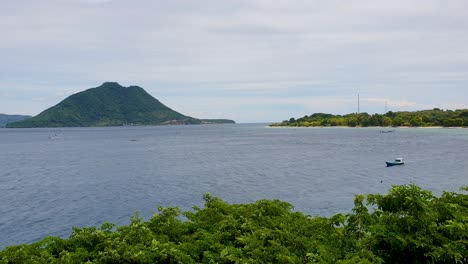 Vista-Panorámica-Del-Océano-Con-Un-Pequeño-Barco-Pesquero-Y-Una-Isla-Tropical-Volcánica-En-La-Isla-De-Alor-En-Las-Islas-Menores-De-La-Sonda-Del-Este-De-Nusa-Tenggara,-Indonesia