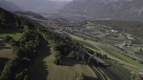 Drone-shot-flying-over-Lago-di-Santa-Giustina-near-Trentino-in-Italy-on-a-cloudy-day-with-mountains-and-water-surrounded-by-green-fields-and-trees-LOG