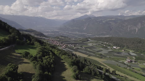Drohnenaufnahme-Aus-Tesimo,-Italien,-Mit-Blick-Auf-Das-Bozner-Tal-Zwischen-Hügeln-Und-Bergen-An-Einem-Sonnigen,-Aber-Bewölkten-Tag-Mit-Wolken