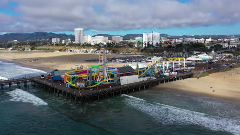 Panoramic-drone-shot-circling-toward-the-Santa-Monica-pier,-in-sunny-Los-Angeles