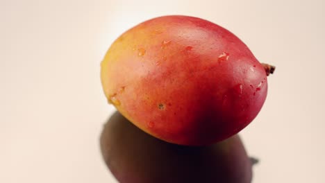 El-Mango-Gira-Sobre-Una-Superficie-Reflectante-Plateada-En-Cámara-Lenta-Brillando-Y-Reluciendo