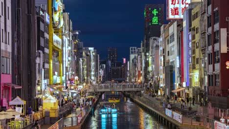Nachtzeitraffer-Vorbeifahrender-Boote,-Menschen-Und-Beleuchteter-Schilder,-Blick-Von-Der-Ebisu-Brücke,-Dotonbori-Kanal,-Namba,-Osaka,-Japan,-Neigung